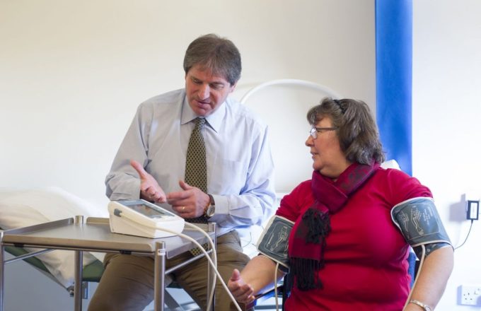Doctor checking blood pressure in both arms