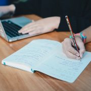 students at laptop and writing in a notebook