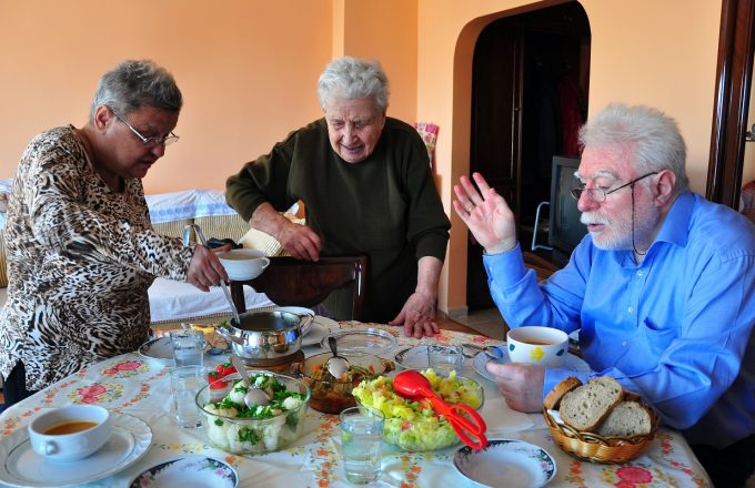 Older people around a table to eat