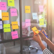 Student sticks sticky notes to office wall to help think creatively about research