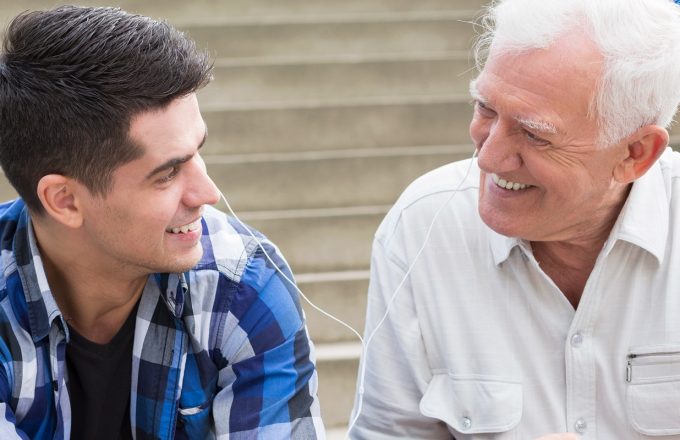 Young man sharing the music with his grandfather