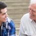 Young man sharing the music with his grandfather