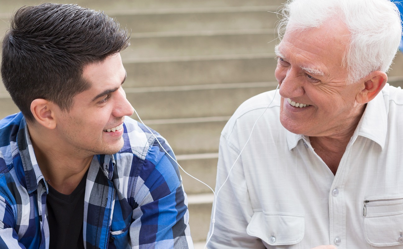 Young man sharing the music with his grandfather