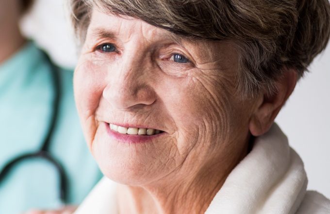 Senior smiling woman and medical care in hospital