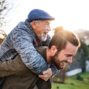 Senior father and his young son walking in nature, having fun.