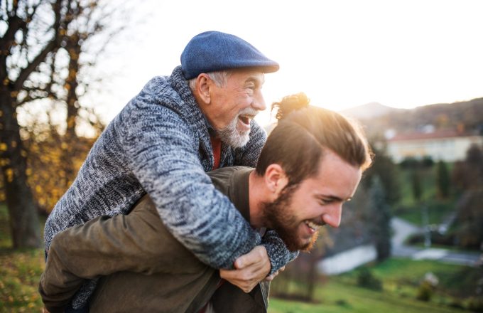 Senior father and his young son walking in nature, having fun.