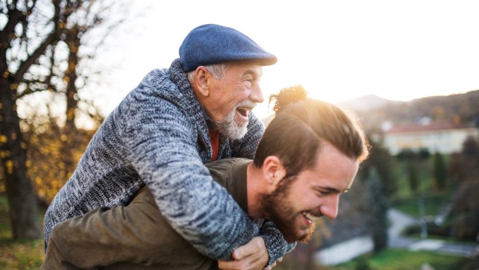 Senior father and his young son walking in nature, having fun.