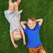 children lying on the green grass in the Park.