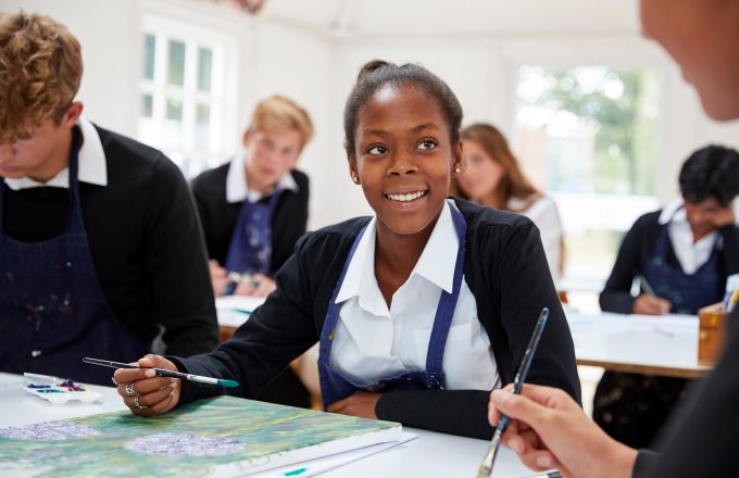 Group Of Teenage Students Studying Together In Art Class