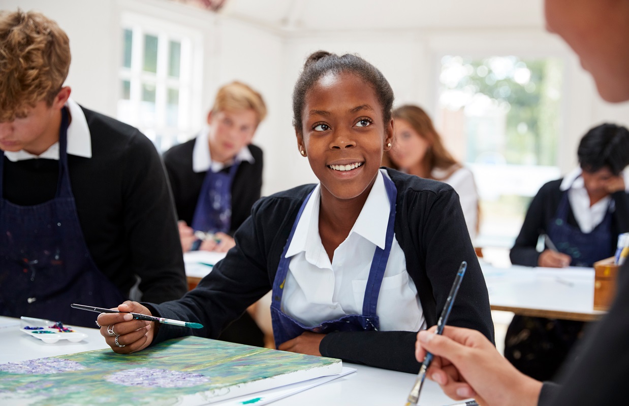 Group Of Teenage Students Studying Together In Art Class