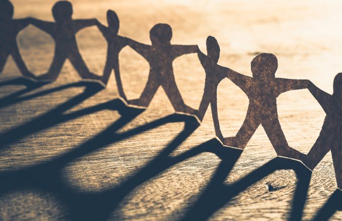 Human chain paper with light and shadow on wood table