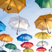 Multi-coloured umbrellas floating in a blue sky