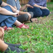 People sitting on grass in a semicircle talking