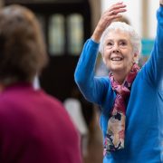 An older lady exercising in a class