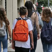A group of young people walk down a city street
