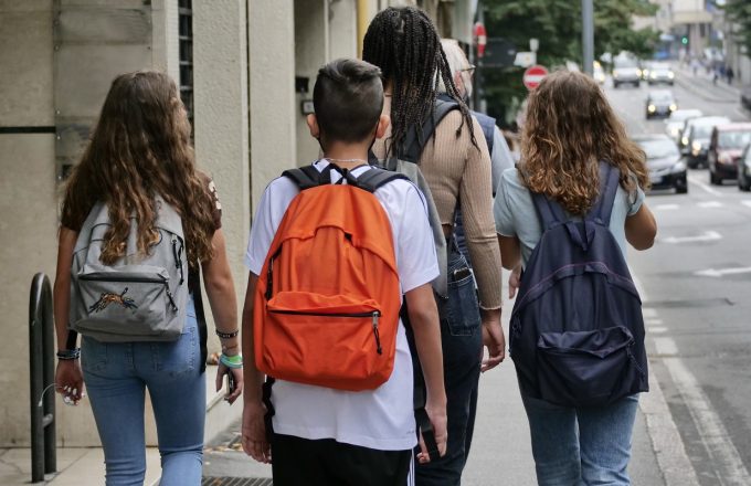 A group of young people walk down a city street
