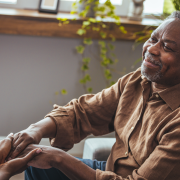 Female carer holding hands of senior man