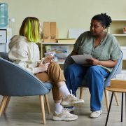 Woman in professional role talking to teenage girl at office