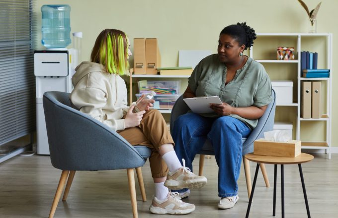 Woman in professional role talking to teenage girl at office